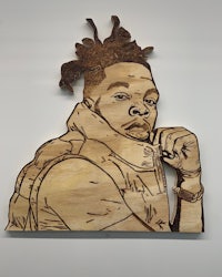a wood carving of a man with dreadlocks