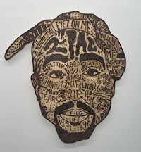 a wood carving of a man with words on it
